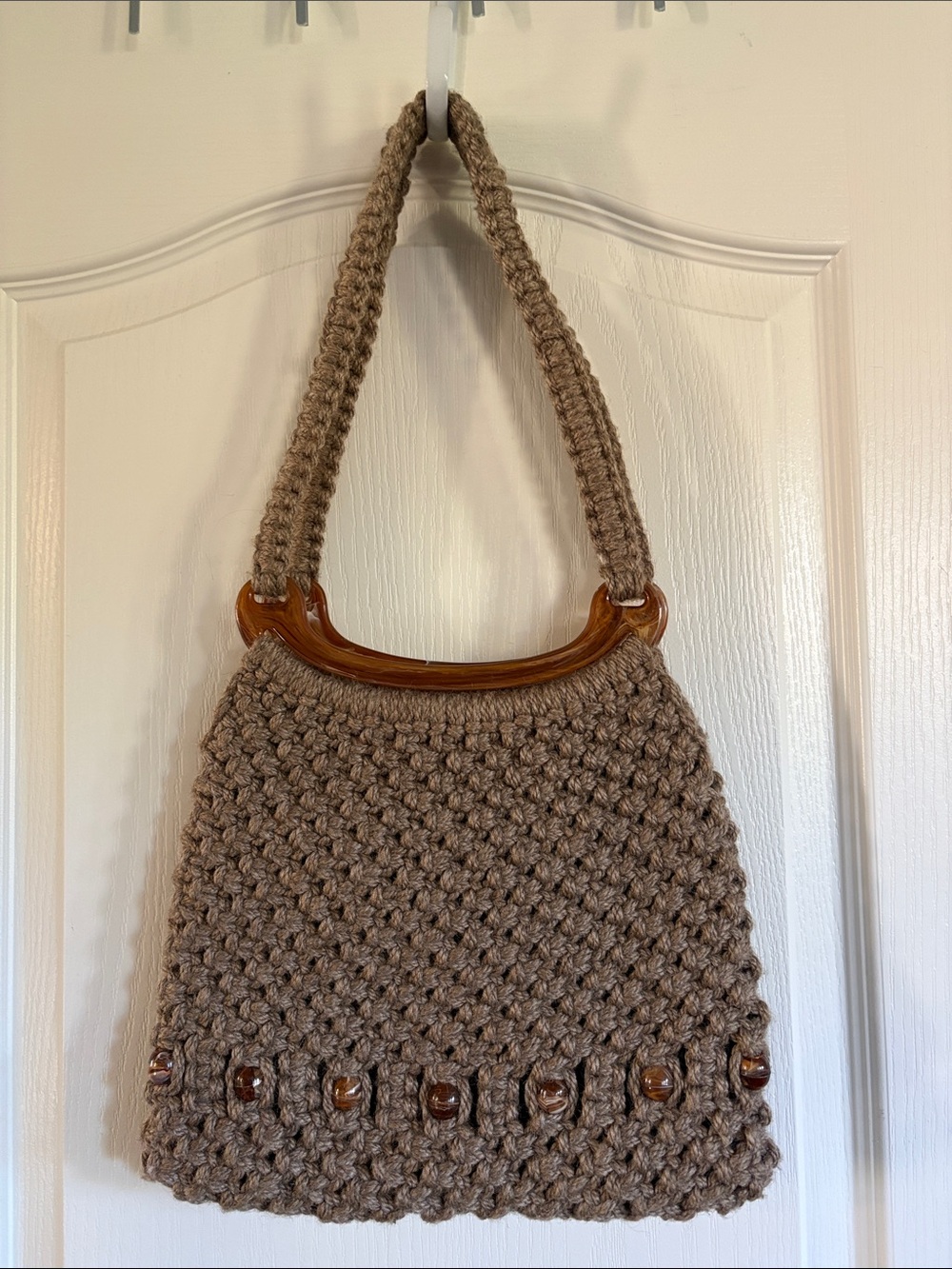 Vintage brown macrame handbag with tortoiseshell-style handle and bead detail.